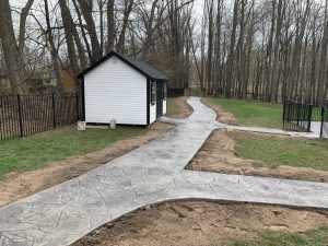 Stamped concrete walkway extending to a shed