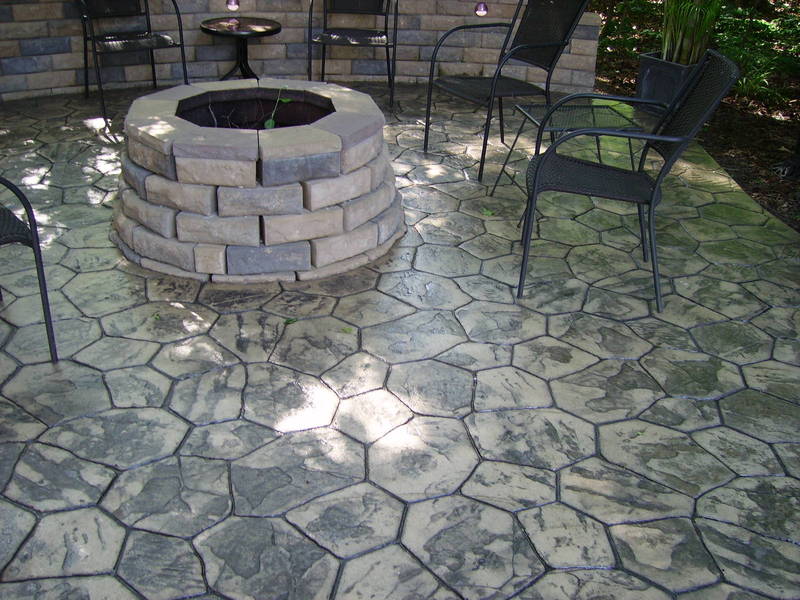 Custom fire pit int eh center of a stamped concrete patio