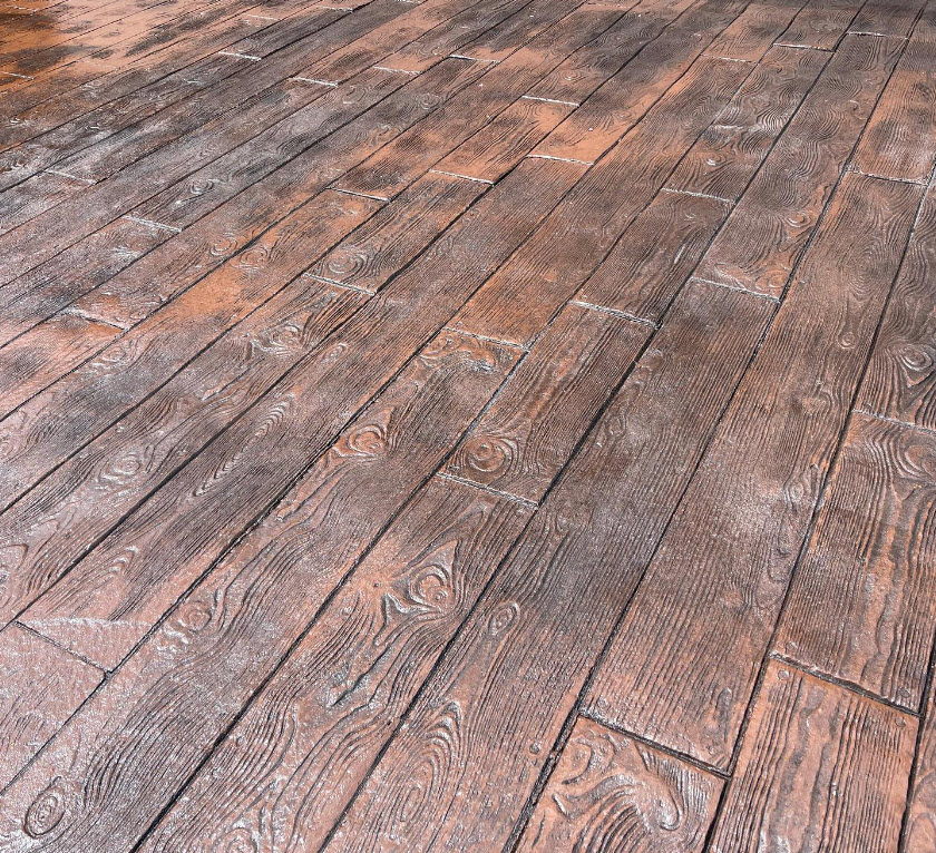 Wood grain simulated stamped concrete patio surface view.